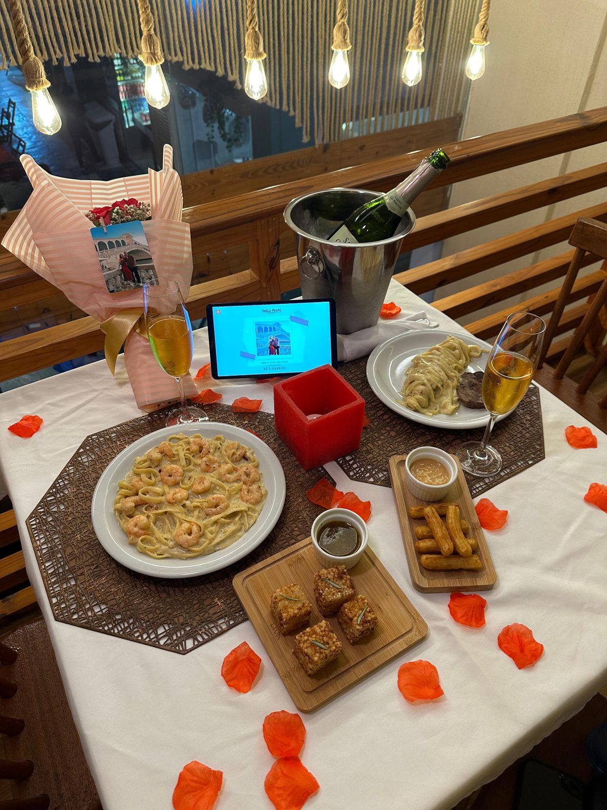 Mesa decorada para jantar romântico com espumante e pétalas no Della Peste em Fortaleza